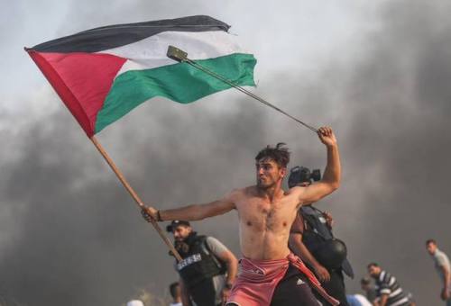 girlactionfigure:Two photos. One of a violent moment as a Palestinian launches a rock at Israeli sol