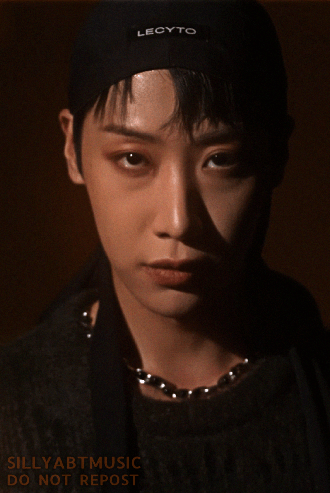 Dongmyeong lit by orange light staring straight into the camera