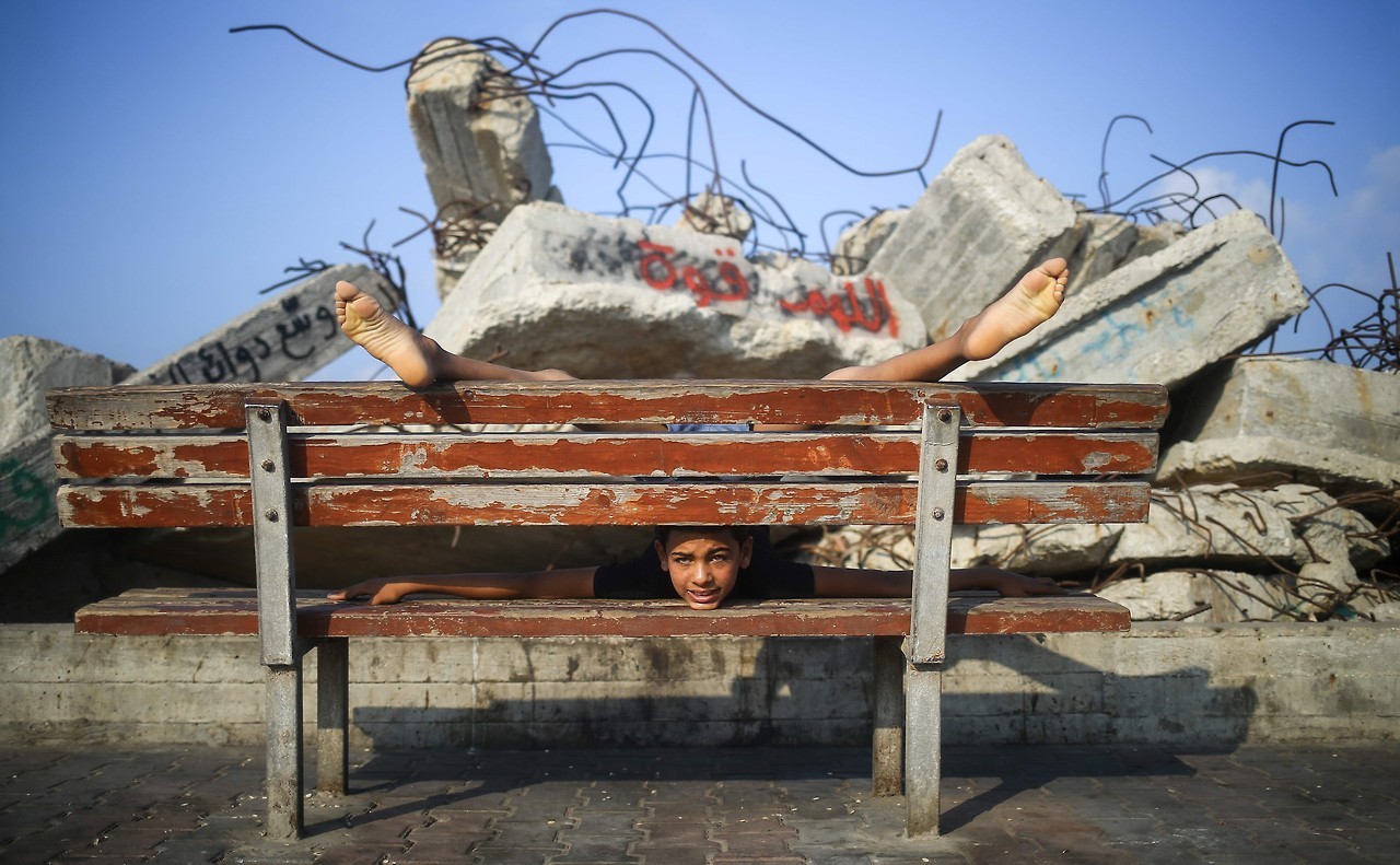 RECORD. Yousef Al-Bahtini, un niño palestino de doce años de edad, invitado por ‘Guiness World Records’ por caminar 20 metros con el cuerpo contorsionado, muestra sus habilidades acrobáticas mientras contorsiona su cuerpo en el puerto de Gaza....