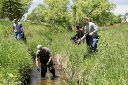 (Left to right) BLM volunteers Travis Bargsten, Sam Cox, Jennifer Schein Dobb and Tyson Finnicum collect trash from Dry Creek during the spring cleanup.