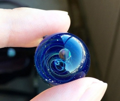 zombies-with-radios:  http://plusalpha-glass.com/index.html  Artist Satoshi Tomizu creates small glass spheres that appear to be miniature solar systems or galaxies, in which planets made of opal are circling into spirals of colored glass and gold flakes.