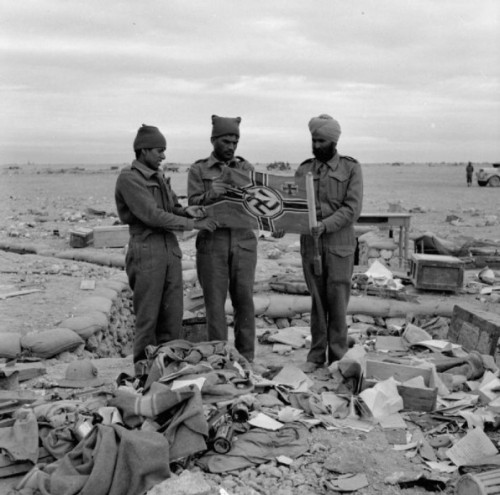 Soldiers of the 4th Indian Army hold a German flag captured in North Africa, World War II December 1