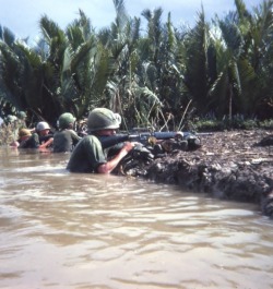 vietnamwarera:   Caught in midst of canal crossing, members of 3rd Plt. CoB 2/3 199th Light Inf. Bde. return fire.  Mekong Delta, s/w of Saigon 1967.  Submitted by a veteran. 