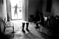  Boy Ponders His Father’s Prosthetic Legs, Sierra Leone, 1999, Stuart Freedman