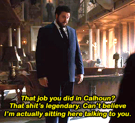 Gif 9: Hazel stands in the Umbrella Academy living room. He seems almost flustered when he tells Five "That job you did in Calhoun? That shit's legendary. Can't believe I'm sitting here actually talking to you."