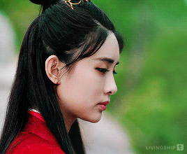 Green gif of Wen Qing, shown in side profile shoulders up, turning to look up.