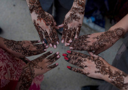 Pakistani girls show their hands painted with henna in Karachi on Aug. 8, 2013.