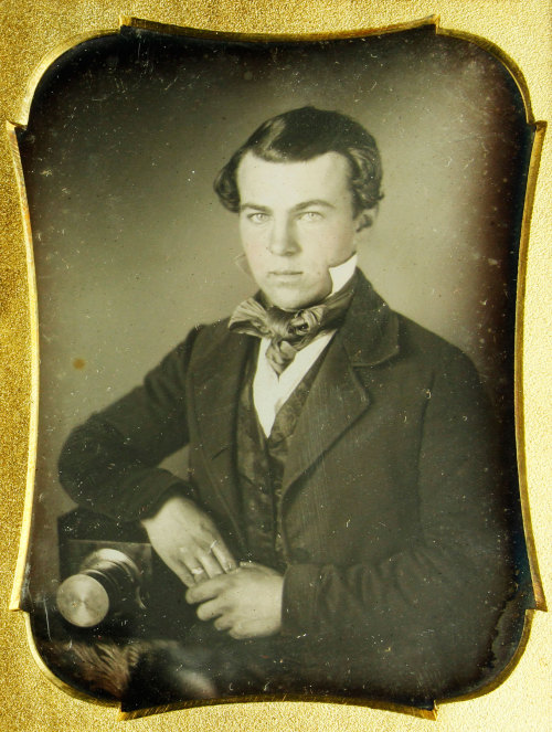 Daguerreotype of a a young photographer sitting beside his camera (Kaminski auctions)