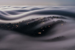 sixpenceee:  Italian photographer Lorenzo Montezemolo climbed Mt. Tamalpais to capture Marin County, California covered with a river of fog lit by a full moon. He later wrote that he had “compressed 186 seconds of moonlit fog into an instant.”
