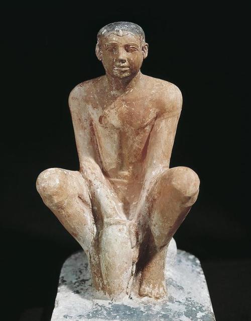 Statuette of a Man Coating a Jar with ClayThe statuette portrays a seated servant holding a jar betw