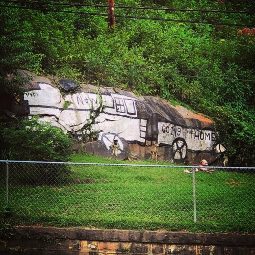 July 31, 2018. “Going Home”. A small train mural painted on a large rock in the yard of 