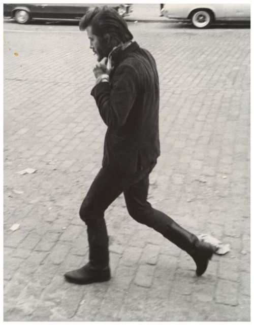 Leon Levinstein (American; 1910–1988)Man in Boots Walking and Adjusting His Collar, New York City Ge