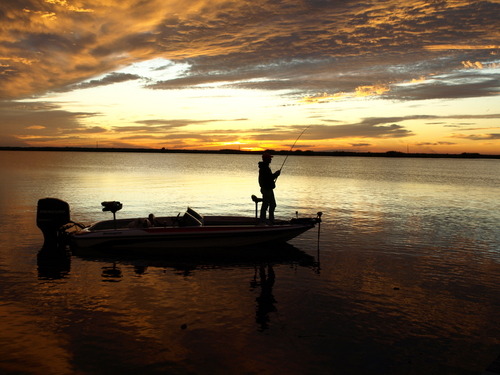 Girl bass fishing on boat