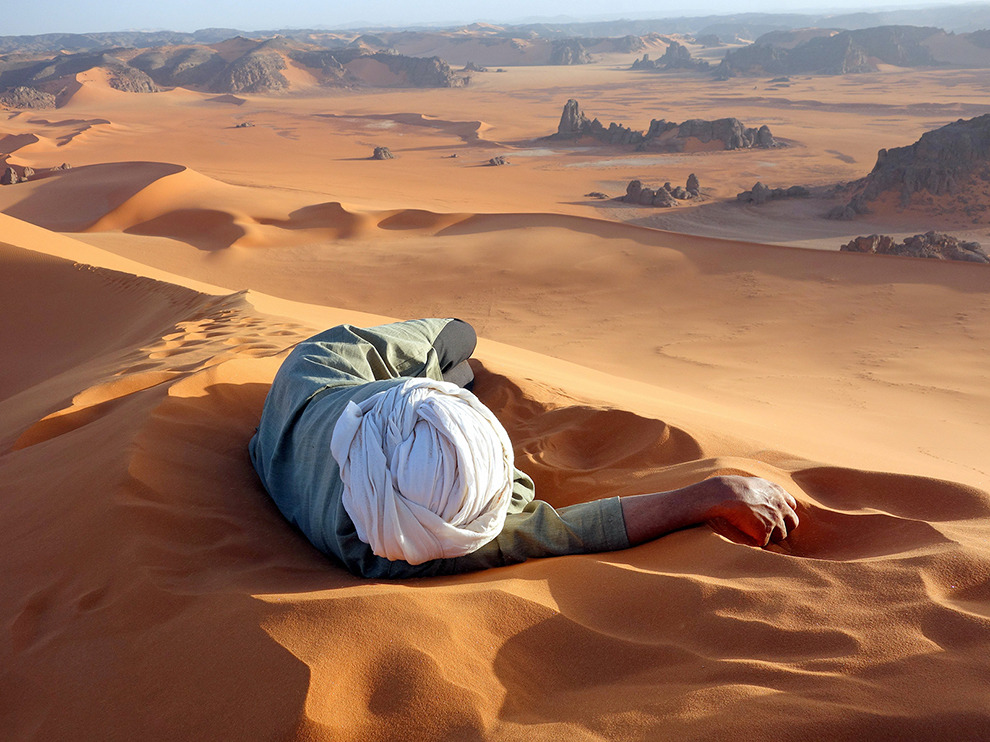 A Tuareg guide rests at the summit of Tin-Merzouga, the largest dune (or erg) in