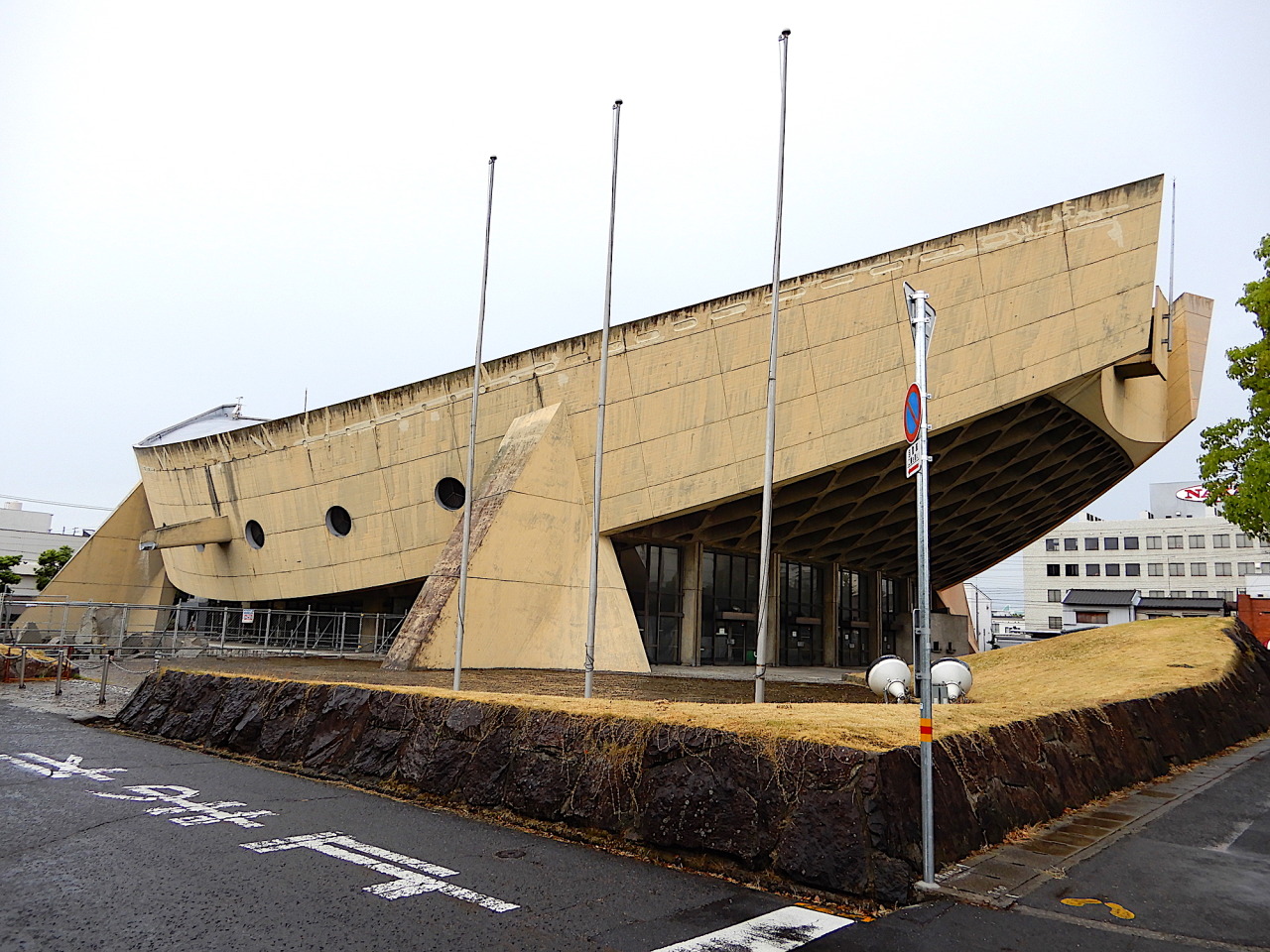 香川県立体育館。
.
瀬戸内海からイメージされたのか、土着的な船を思わせる形状。
.
湾曲し、反り上がった2枚の壁（梁）が、
4つの脚で支えられ、空中に浮かび上がっています。
.
その2枚の壁に挟まれるようにして、
真ん中に競技場が浮かんでいます。
そして、前後に迫り上がるような部分が、
およそ1300人を収容する観客席となっています。
.
さらに曲面を描く屋根も、その2枚の壁から吊り下げられています。
.
「すべてが計算し尽くされた、世界に類例を見ない弾性構造計算の極致」…。
.
すべてが微妙な...