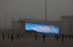 xantime:A bright video screen shows images of blue sky on Tiananmen Square during a time of dangerous levels of air pollution, on January 23, 2013 in Beijing. #