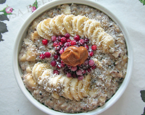 parrotdream:  banana oatmeal seasoned with cacao nibs, honey and salt, topped with banana, lingonberries, shredded coconut and peanut butter 