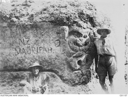 scrapironflotilla: Two unidentified soldiers standing in front of a Maori carving in a main sap (dee