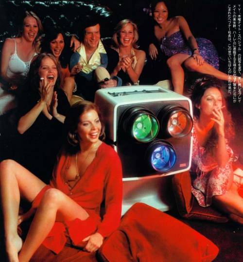Hugh Hefner and the 1977 Playboy Playmates pose with the Advent VideoBeam 1000 Projection System, Pl