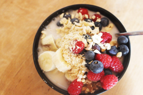 Vegan porridge with berries, bananas, chopped cashews and coconut milk.