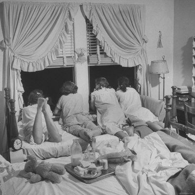 the50s:Teenage girls talking to boys downstairs in a sleepover in the 50s.