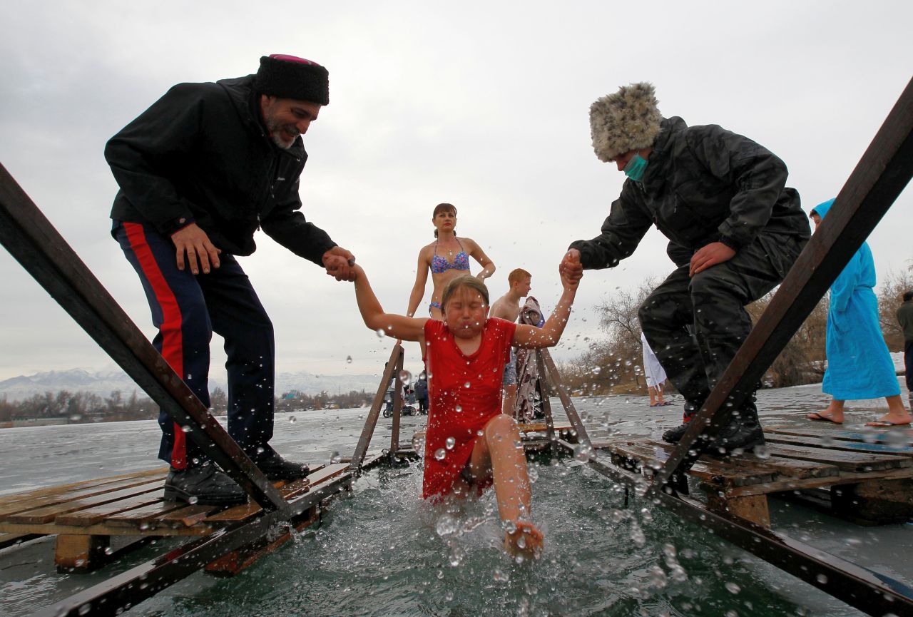 Una ragazza è aiutata da cosacchi mentre fa un tuffo nelle acque gelide durante le celebrazioni della festa cristiana ortodossa dell'Epifania nel villaggio di Leninskoye, in Kirghizistan, il 19 gennaio 2021.
(Foto di Vladimir Pirogov)