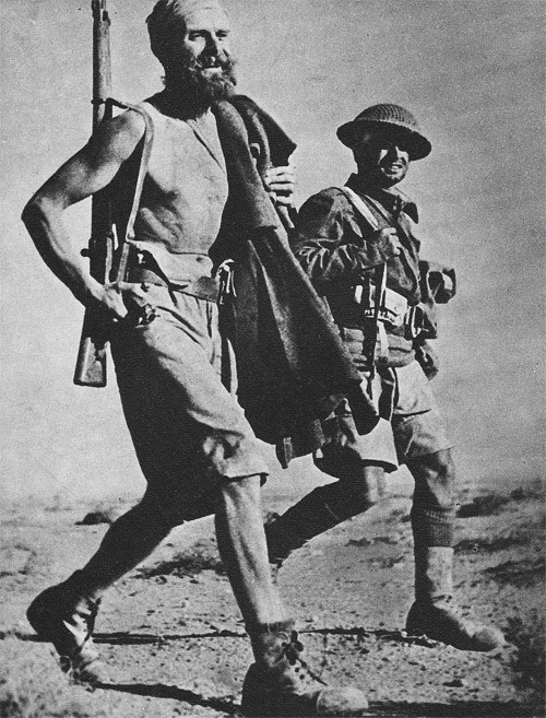 warhistoryonline:Battle-hardened veterans of Montgomery’s Desert Rats stride along a desert track, N