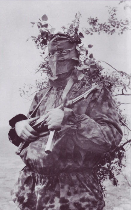 demdeutschenvolke: “ Waffen-SS Soldier in full Splittertarn-pattern uniform, with a non-standard face mask. The camouflage smock is worn over field gear, thus the bulge on the stomach. ”