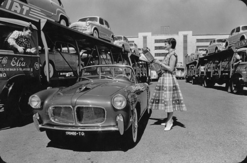 A woman watches a parade of different Fiat models driven around the test track of Fiat’s Miraf