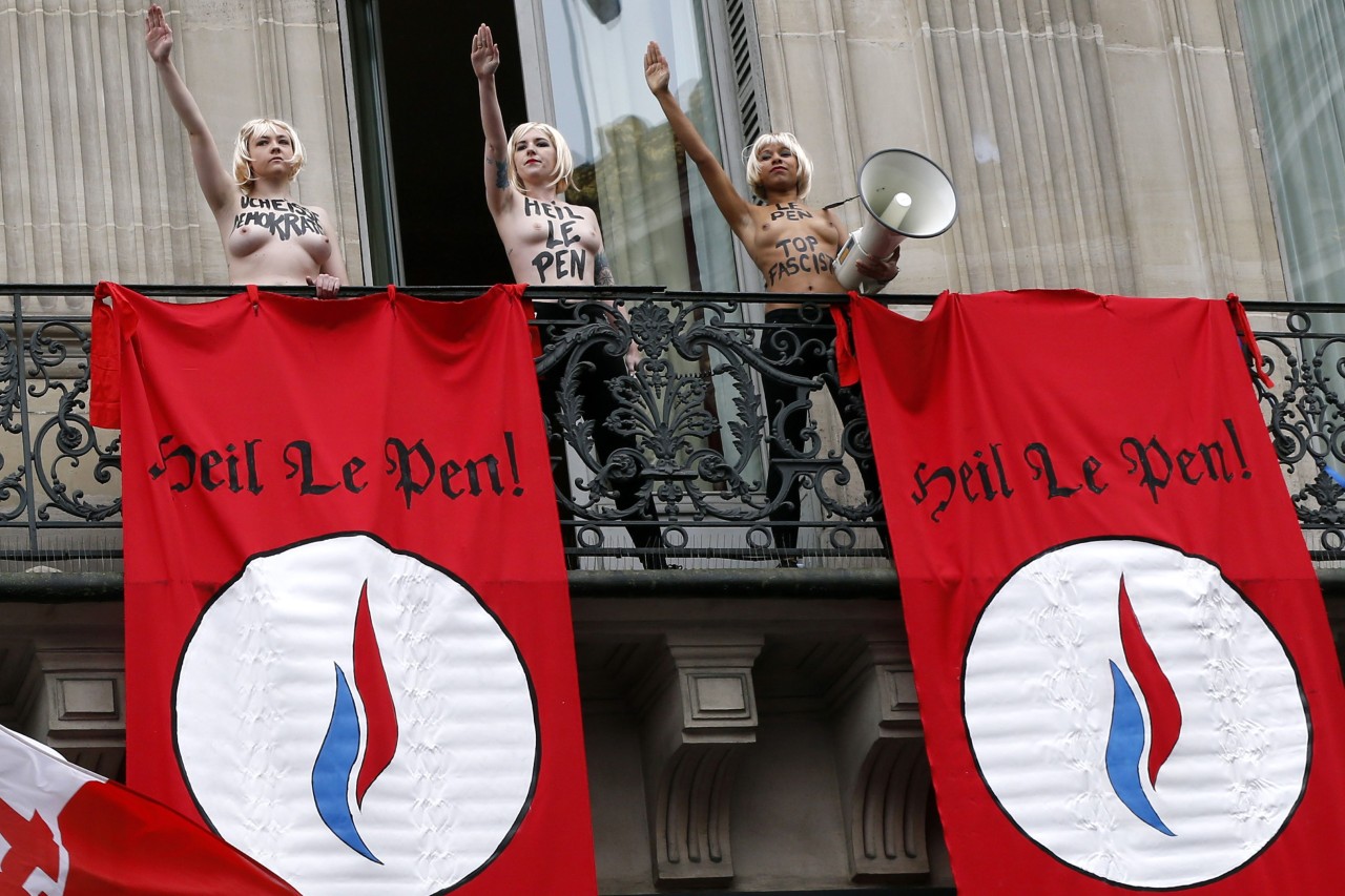 FEMEN. Los guardias de seguridad detienen a activistas de Femen en topless que realizan el saludo nazi desde el balcón contra el partido político Frente Nacional de Marine Le Penn de extrema derecha de Francia durante un mitin FN en honor a Juana de...