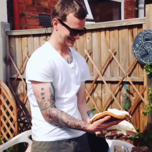 Tattooed guy gives his mate a pie in the face