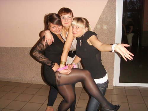 Partying woman flashing thigh in black control top pantyhose. Woman in pantyhose