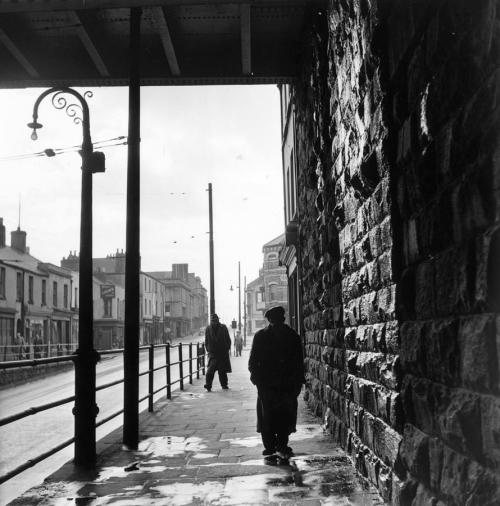 Bert Hardy. Tiger Bay: A man walking under a railway bridge in the dockland area of Cardiff, known a