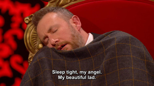 [ID: Two screencaps from Taskmaster. Alex Horne is slumped over in his chair, feigning sleep while d