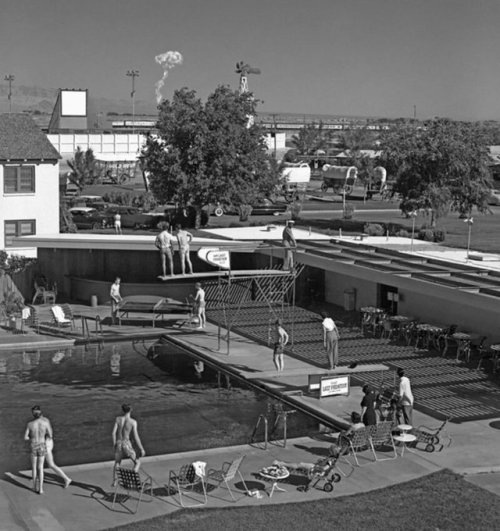Swimmers at a Las Vegas hotel watch a mushroom cloud from an atomic test 75 miles away, 1953