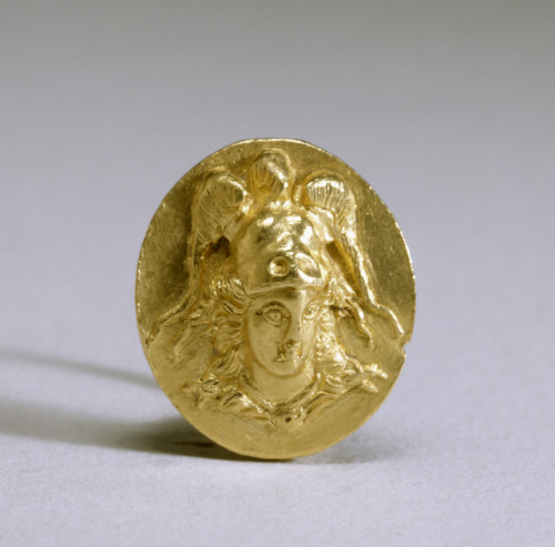 lionofchaeronea:Ancient Greek gold ring depicting Athena, helmeted and with her aegis around her nec