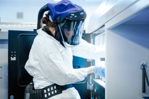 Emily, a process engineer at GE Aviation in Auburn, AL is all suited up to remove a print from a Dir