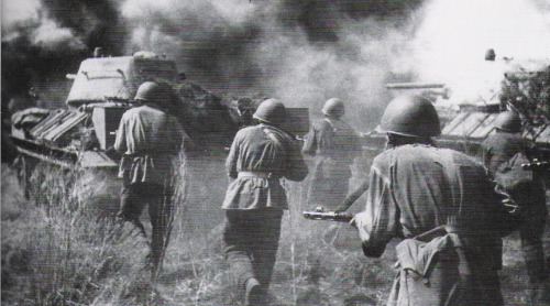 Soviet soldiers advance behind T-34 medium tanks. Orel, Soviet Union. August 1943.