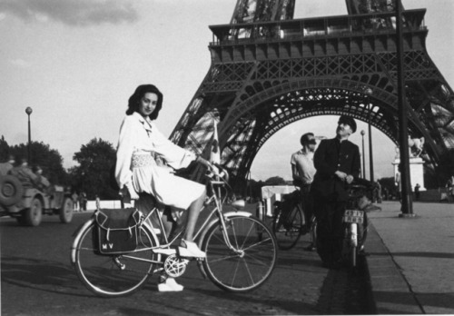 Fashion Assignment - girl on bike in front of Eiffel Tower, Paris, 1944 by  Lee Miller