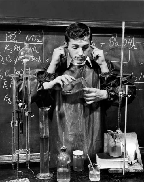 Alfred Eisenstaedt - Popular Smith High School senior, Earl Reum, 17, mixing a fake chemical formula with two hands as two other hands stop up his ears while he amuses his chemistry class when the teacher is out of the room, 1948.