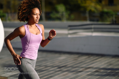 beinghealthytips.net Black woman, afro hairstyle, running outdoors in urban road.