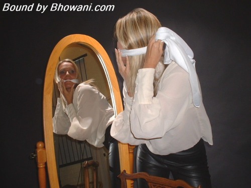 graybandanna:  Lucy Zara gags herself in the mirror with a white scarf before being tied to a chair, gagged with another scarf and blindfolded 