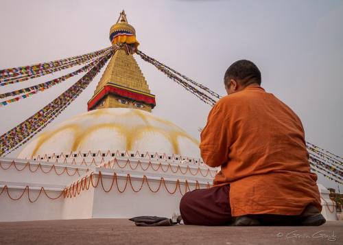 A Buddhist monk reciting prayers beside the sacred stupa at...