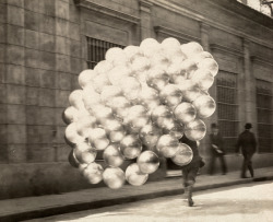 natgeofound:  A balloon vendor runs across a road with a trailing mass of balloons in Buenos Aires, November 1921.Photograph by Newton W. Gulick, National Geographic 