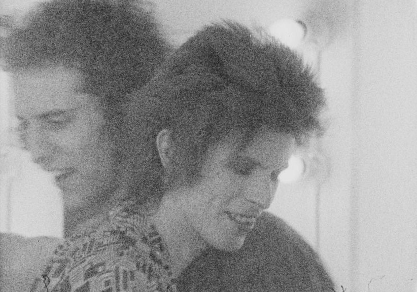 berlin-1976:  Super cute, super grainy pic of David Bowie and Mick Rock hugging,