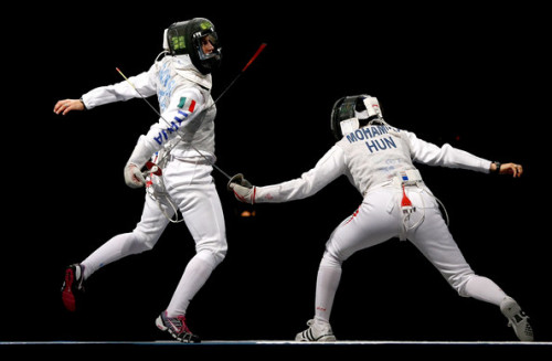 modernfencing:[ID: a foilist pulling back her arm and stepping in to parry her opponent’s atta