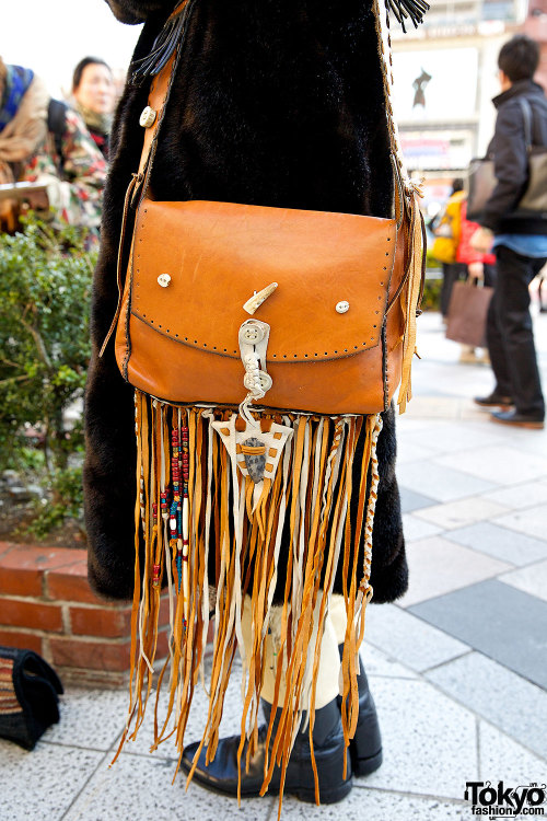 Tokyo vintage boutique employee wearing a vintage fur coat with a resale hat, resale leather boots, 