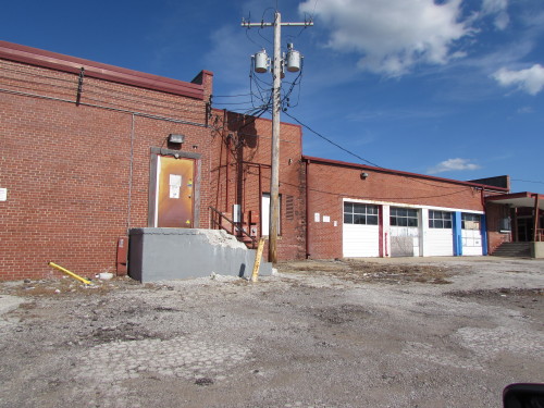 Crumbling concrete steps and boarded up garage doors from when there was a Western Auto store here.