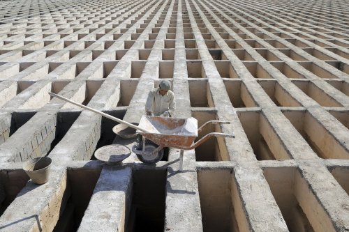 A cemetery worker prepares new graves at the Behesht-e-Zahra cemetery on the outskirts of Tehran, Ir