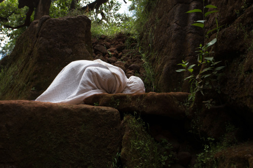 aqutiv:“Kissing the ground”,  An Ethiopian orthodox nun praying at the entrance to 